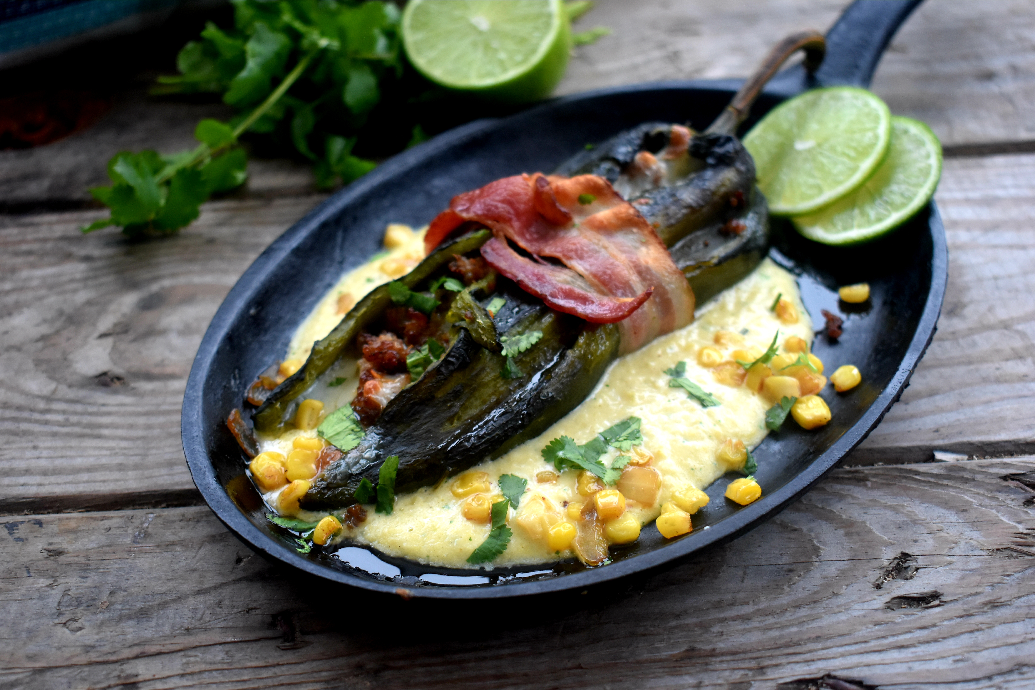 Stuffed poblano wrapped in bacon in cream corn sauce