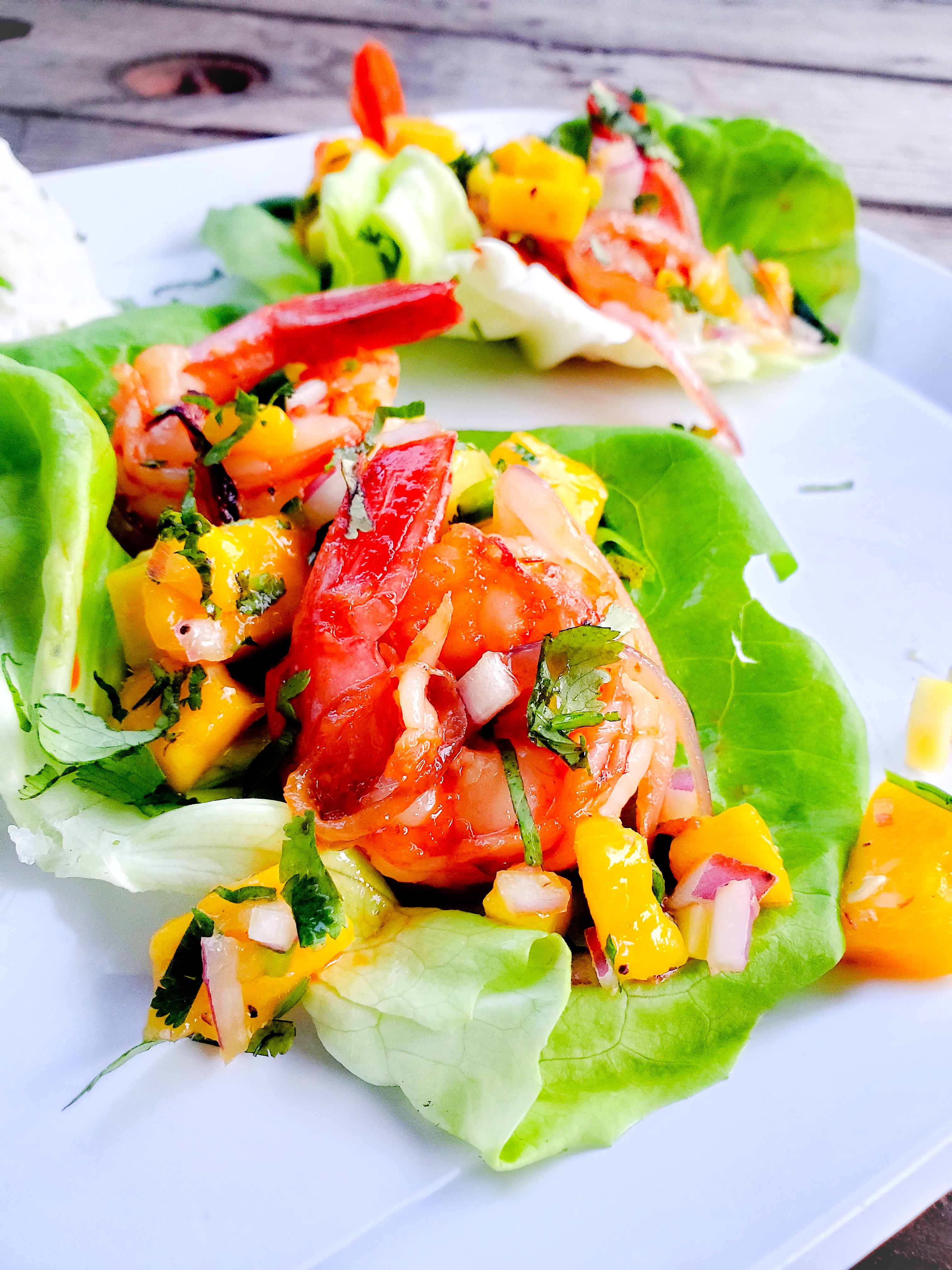 Bite size lettuce wraps with mango chile shrimp and mango salsa