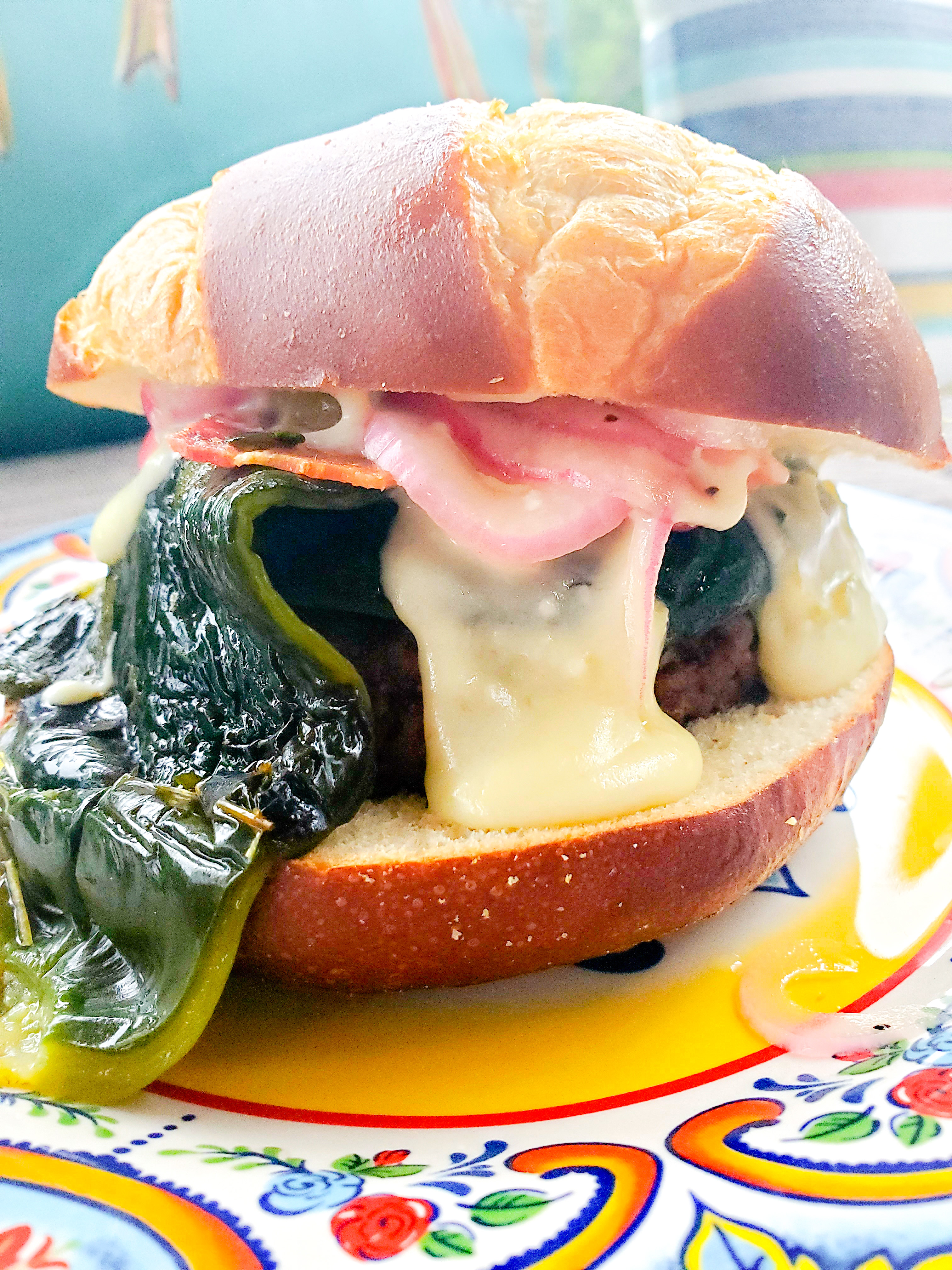 Ahhh, the sexy Poblano Burger. The perfect addition to your Memorial Day BBQ. Inspired by flavors of the Southwest, this burger is topped in a luscious green chile queso layered with thick cut smokey bacon, fire roasted poblano peppers and pickled red onions.