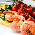 Garlic prawns with blistered tomatoes and Swiss chard over creamy polenta