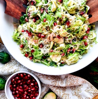 Shallot lemon vinaigrette drizzled over this Shaved Brussels Sprouts Salad with grated parmesan, pomegranate and toasted bread crumbs.
