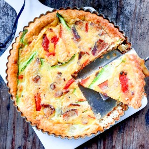 New Woman Cheese, Bacon, Zucchini and Roasted Red Pepper Quiche takes flavor from Jamaican jerk spiced cheese, farm eggs and a butter crust.