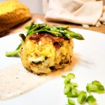 Crab Cake with Pink Peppercorn Sauce full of Dungeness crab with crispy edges paired with a peppery agave cream sauce.