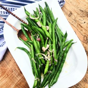 Shallot Citrus Green Beans served cold after being quickly marinated in a light agave lime dressing with shaved shallots.