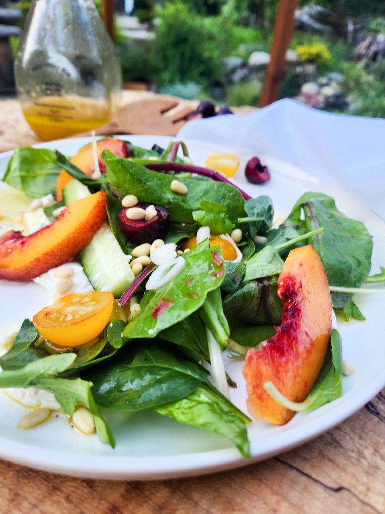 Stone Fruit Salad layers fresh, seasonal nectarine, cherry, cucumber, tomato, greens and pine nuts over ricotta with agave lime vinaigrette.