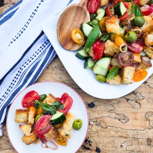 Panzanella Salad is simple and fresh with vine ripened tomatoes, olives, cucumber, peppers, basil, rustic bread and red wine vinaigrette.