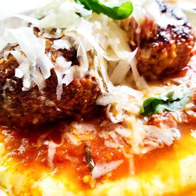 Roman Meatballs with Polenta combine ground beef, Italian sausage and prosciutto with pine nuts and fresh basil over creamy polenta.
