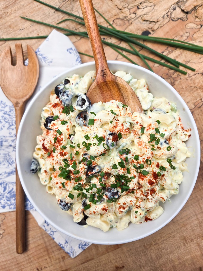 Chrissey Lou's Pasta Salad is a classic macaroni salad with creamy dressing, eggs, olives, celery, red onion and chives.