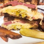 Reuben Sandwich layered with corned beef, sauerkraut, Swiss cheese and Russian dressing all on marbled sourdough rye bread